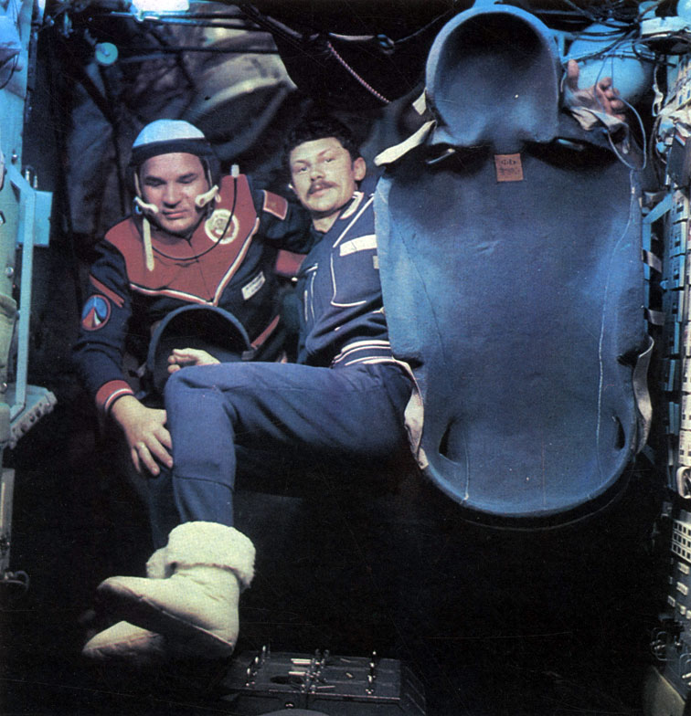 Близится завершение полета. В. Кубасов и Б. Фаркаш переносят индивидуальные ложементы кресел в спускаемый аппарат корабля 'Союз-35'